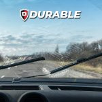 A picture of a windshield taken from the inside of a car; the wiper turned on and some water streaking.