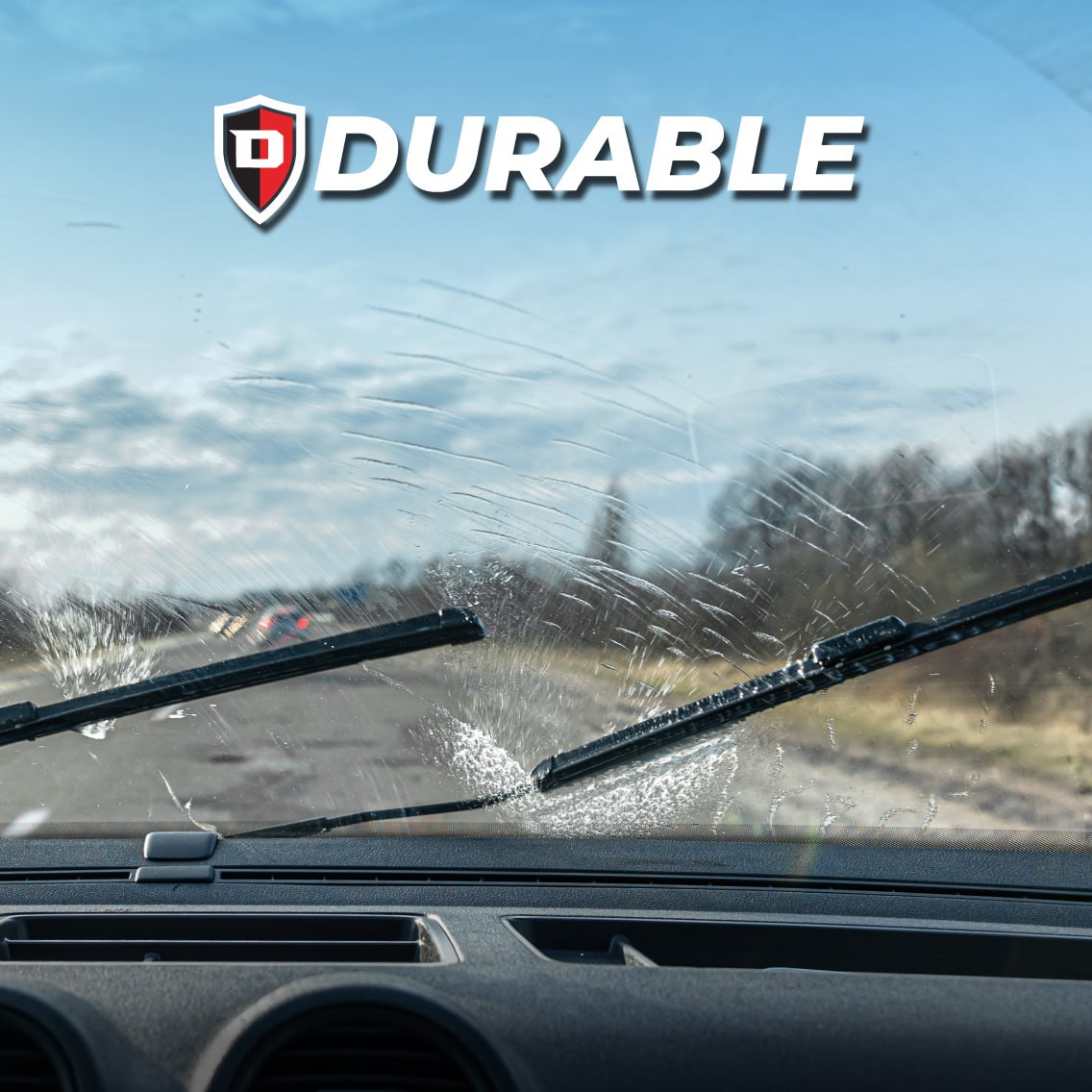 A picture of a windshield taken from the inside of a car; the wiper turned on and some water streaking.